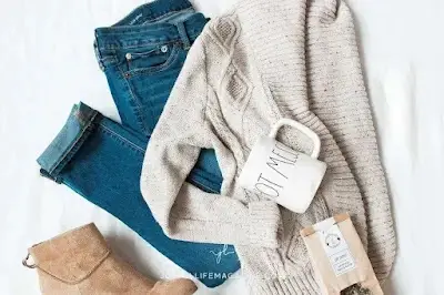 Flat lay of casual capsule wardrobe pieces with jeans, sneakers, and accessories arranged neatly